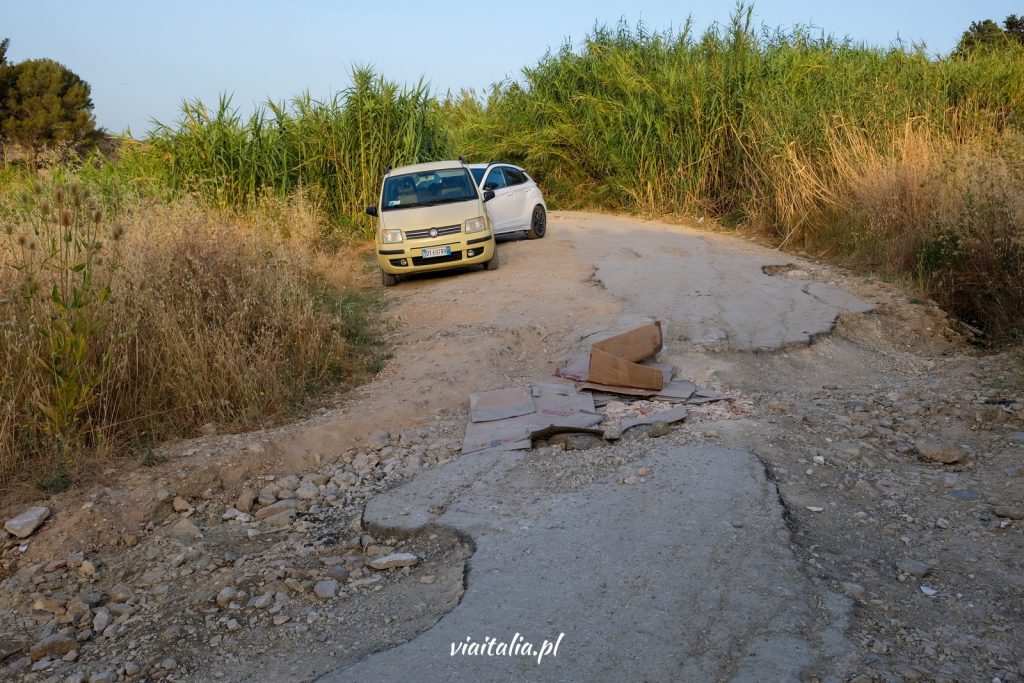 Damaged road surface in front of parking lot